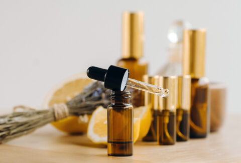 Essential oil in bottles with lemon and lavender fragrance, lying on a wooden surface