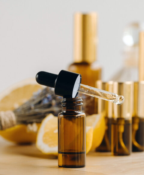 Essential oil in bottles with lemon and lavender fragrance, lying on a wooden surface