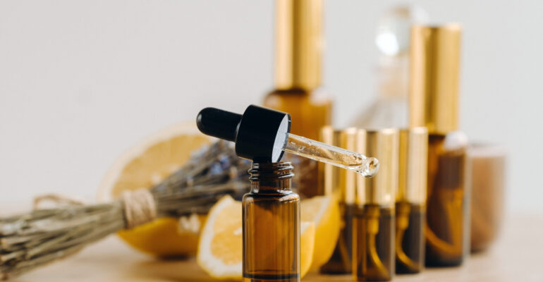 Essential oil in bottles with lemon and lavender fragrance, lying on a wooden surface