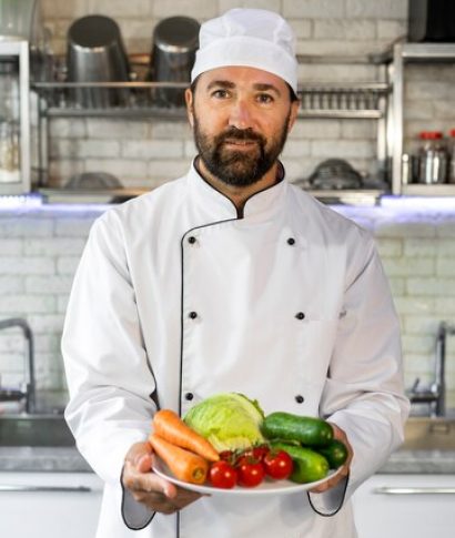 male-chef-kitchen-holding-plate-fresh-vegetables_23-2149646226